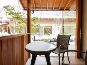 a patio with a table and chairs on a porch at Keiryuso Siorie in Matsumoto