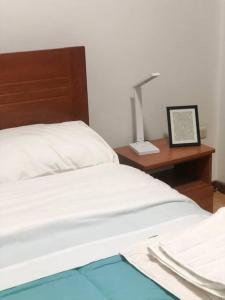 1 dormitorio con 1 cama y escritorio con lámpara en Inigualable Ubicación-Súper acogedor-Amplio-a 5 Cdras del Centro historico, en Trujillo