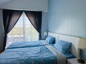 a blue bedroom with a bed and a window at Cozy life ไออุ่น in Khao Kho