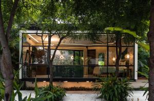 a glass house in a garden at night at San Trópico Boutique Hotel & Peaceful Escape in Puerto Vallarta