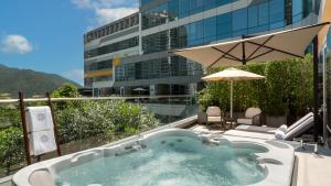 a jacuzzi tub on a balcony with a building at The Silveri Hong Kong - MGallery in Hong Kong