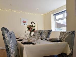 a dining room with a table with a white table cloth and chairs at Number Five in Filey
