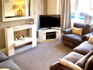 a living room with a tv and a couch and a fireplace at Number Five in Filey