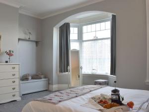 a white bedroom with a large bed with a window at Number Five in Filey
