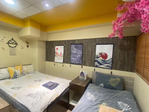 - 2 lits dans une chambre avec des affiches sur le mur dans l'établissement AMU Dreamhouse 阿木旅舍, à Hong Kong