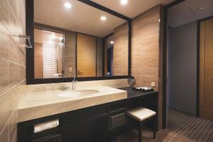 ein Bad mit einem Waschbecken und einem Spiegel in der Unterkunft Rihga Royal Gran Okinawa in Naha