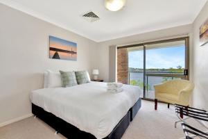 een slaapkamer met een groot bed en een raam bij Lakeview Oasis with Panoramic Waterfront Views at Fishing Point in Fishing Point