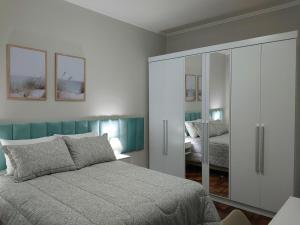 a bedroom with a bed and a glass closet at Aconchego e tranquilidade junto ao H. Mãe de Deus in Porto Alegre