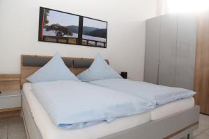 sypialnia z łóżkiem z białą pościelą i lustrem w obiekcie Villa Aurum w mieście Greetsiel