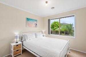 een slaapkamer met een wit bed en een raam bij Shoreside Waters in Portarlington