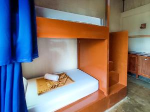 an empty bunk bed with a blue curtain in a room at Lexias Hostel and Workspace - El Nido in El Nido