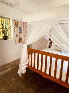 a bedroom with a bed with a canopy at Cafe Ceylon in Koggala