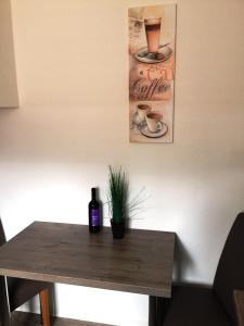 a table with a bottle of wine and a plant on it at Haus am Eck - Gästehaus und Appartements in Altötting