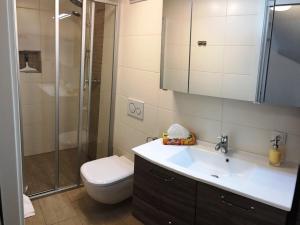 a bathroom with a toilet and a sink and a shower at Haus am Eck - Gästehaus und Appartements in Altötting