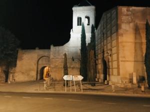 a building with a clock tower at night at Magia en el Arco in Olmedo