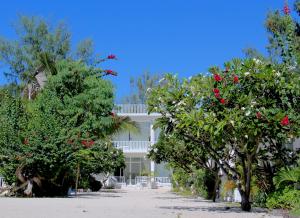 a white house with trees in front of it at Seri Resort Gili Meno in Gili Meno