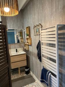 a bathroom with a sink and a mirror at La Boussole centre station proche mer in Agon Coutainville +32 photos