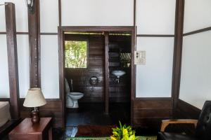 La salle de bains est pourvue de toilettes et d'un lavabo. dans l'établissement Pomelo Restaurant and Guesthouse's Fishermen Bungalow & A Tammarine Bungalow River Front, à Ban Khon