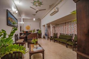 een woonkamer met stoelen, een bank en een tafel bij The Lavitra Udaipur in Udaipur