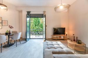 a living room with a couch and a television at Eleusis Suites Α in Elefsina