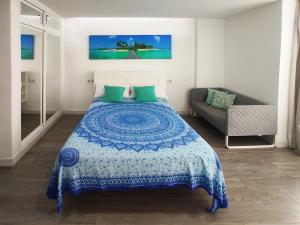 a bedroom with a blue and white bed and a couch at Hercules Suite in Benalmádena +6 photos