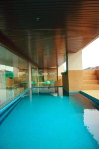 uma piscina com água azul num edifício em The Guest Hotel & Spa em Porto Dickson