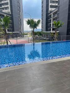 una gran piscina con palmeras y edificios en D'Rinie Sky Homestay, en Kajang