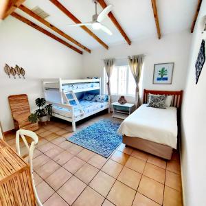 a bedroom with a bed and bunk beds in it at Sky Tyde's Beach House in Port Shepstone