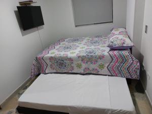 - un petit lit dans une chambre avec un oreiller et une couverture dans l'établissement Envigado Parque Principal - Orquideas piso 3, à Envigado