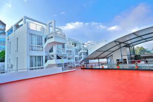 a large white building with a red floor at Grand Signature Hotel & spa in Yercaud