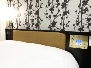 a bedroom with a bed with a clock on the wall at APA Hotel Shin Osaka Minamikata Ekimae in Osaka