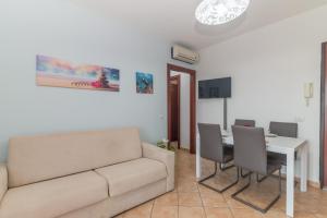 a living room with a couch and a table and chairs at Olbia Mare Apartment in Olbia