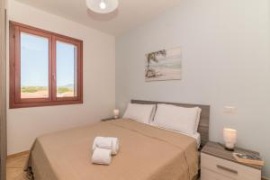 a bedroom with a bed with two towels on it at Olbia Mare Apartment in Olbia