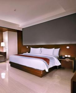 ブカシにあるASTON Imperial Bekasi Hotel & Conference Centerの大きなベッドルーム(白い枕の大きなベッド付)
