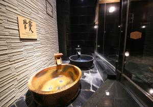 a bathroom with a large wooden tub and a sink at APA Hotel Shinjuku Gyoemmae in Tokyo