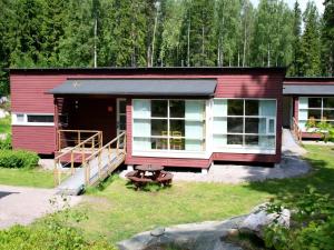 una pequeña casa roja con una mesa de picnic delante de ella en Rastila Camping Helsinki, en Helsinki