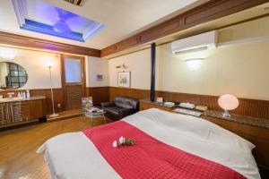 香芝市にあるBLAN VILLA 旧bibiのベッドとソファ付きのホテルルーム