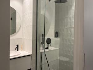 a glass shower in a bathroom with a sink at Apartaments ApturVic en el Centre Històric in Vic