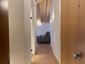pasillo que conduce a una sala de estar con sofá en Apartaments ApturVic en el Centre Històric, en Vic