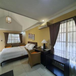 a hotel room with a bed and a desk with a computer at Tengger Guesthouse in Pasuruan +57 photos