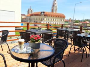 une rangée de tables et de chaises sur un balcon dans l'établissement Hotel Pelikán, à Lučenec