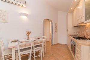 een keuken en eetkamer met een tafel en stoelen bij Dimora di Rosy Pittulongu in Olbia