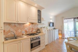 a kitchen with white cabinets and a sink at Dimora di Rosy Pittulongu in Olbia