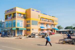 a man walking down a street in front of a building at GIDI LODGE in Tamale