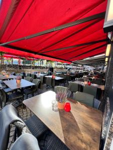 ケルンにあるホテル ドライ クローネンの赤い天井のテーブルと椅子が備わるレストラン
