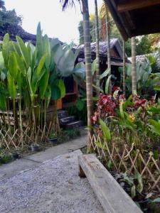 a wooden bench sitting in a garden with plants at Phoxay Ngam Resort in Vang Vieng
