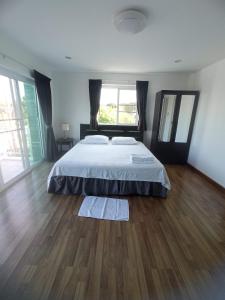 a bedroom with a bed and a wooden floor at Charlie's Angels Hotel Restaurant in Rawai Beach