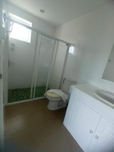 a bathroom with a shower and a toilet and a sink at Charlie's Angels Hotel Restaurant in Rawai Beach