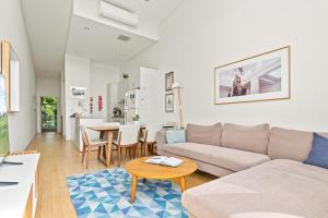 een woonkamer met een bank en een tafel bij Charming Modern Apartment with City Views DUPLICATE in Sydney