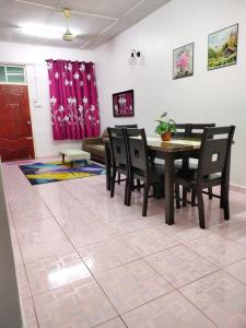 - une salle à manger avec une table, des chaises et un canapé dans l'établissement Rizki Homestay, à Nibung Tebal